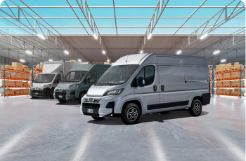 Three commercial vans lined up in a warehouse.