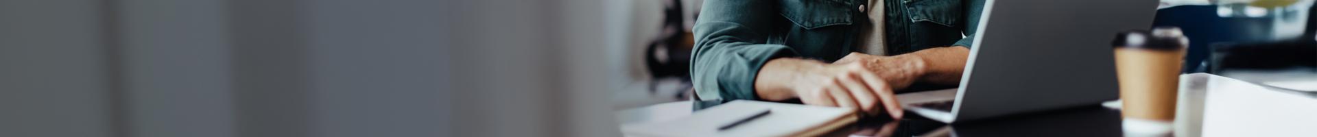 Person typing on a laptop (only their hands are visible).