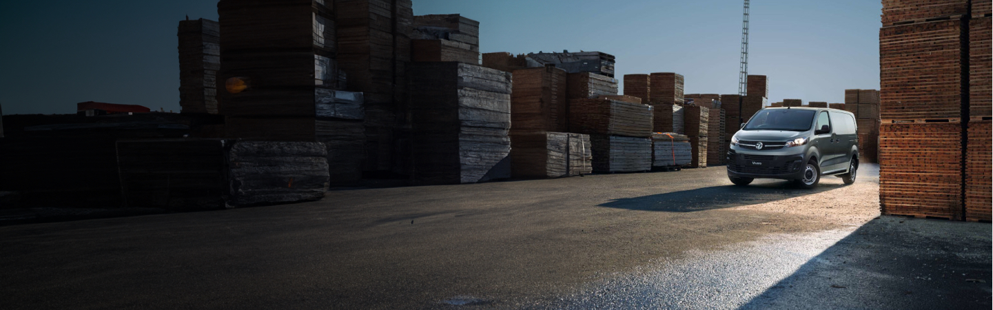 a black van driving through a warehouse courtyard