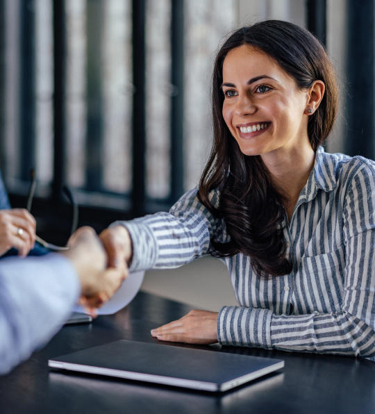 A business woman shaking hands with someone.