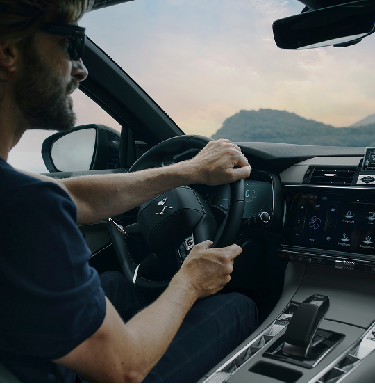 A man driving a car wearing sunglasses.