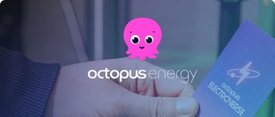 A person holding an Octopus Energy card with the Octopus Energy, pink octopus, logo sitting above the image.